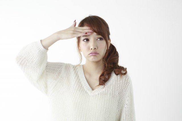額に手の女性