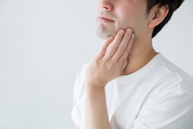 顔さわる男性