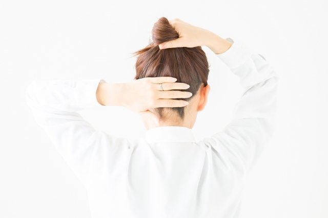 髪をアップにする女性