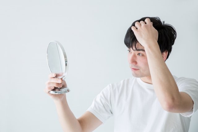 髪を気にする男性