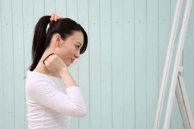 髪を結ぶ女性