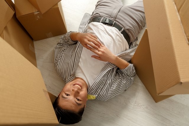 ダンボールに囲まれた男性