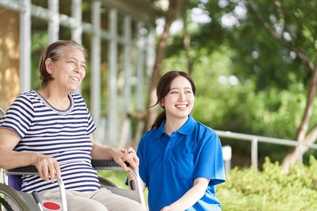 介護士と車椅子の高齢者